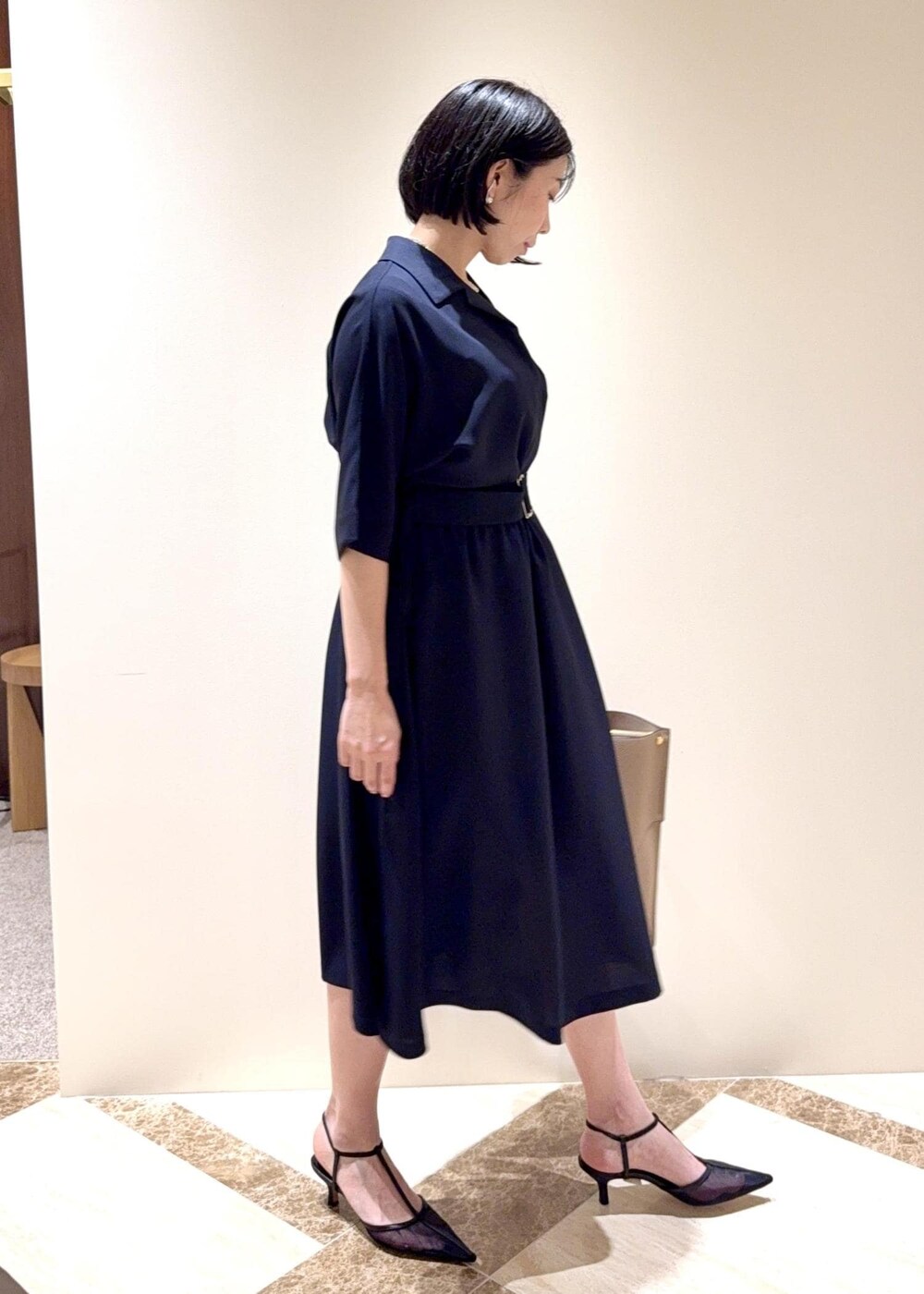 ブラック系のパンプス、ブルー系のワンピース、ベージュ系のトートバッグを着用したレディースの夏コーディネートの2枚目の写真