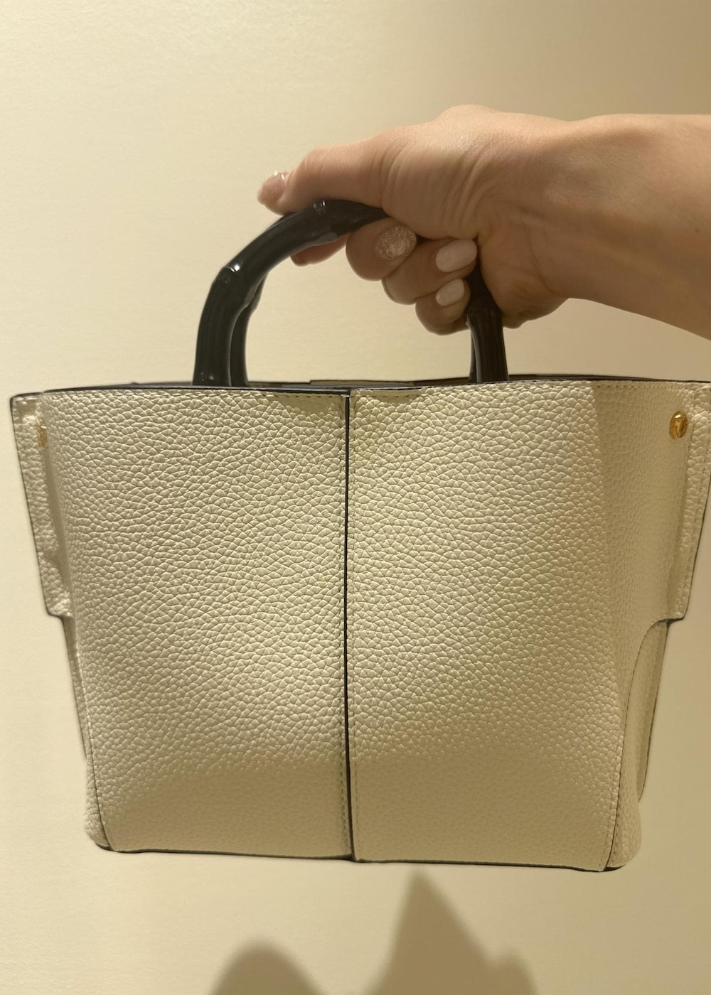 ホワイト系のハンドバッグ、ベージュ系のスカート、ブルー系のデニムジャケットを着用したレディースの春コーディネートの6枚目の写真