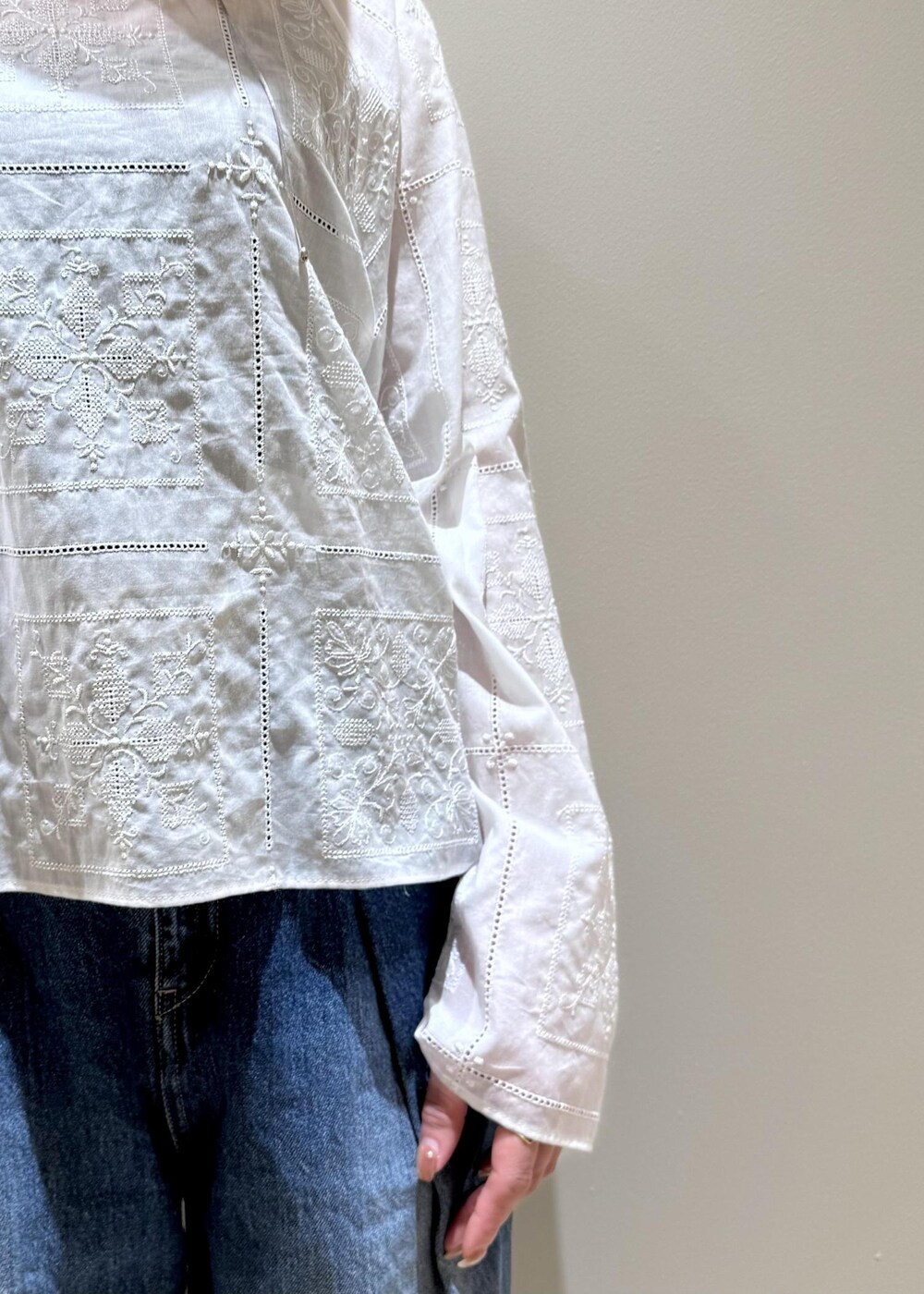 ブルー系のデニムパンツ、ブラック系のサンダル、ホワイト系のシャツ/ブラウスを着用したレディースの春コーディネートの4枚目の写真