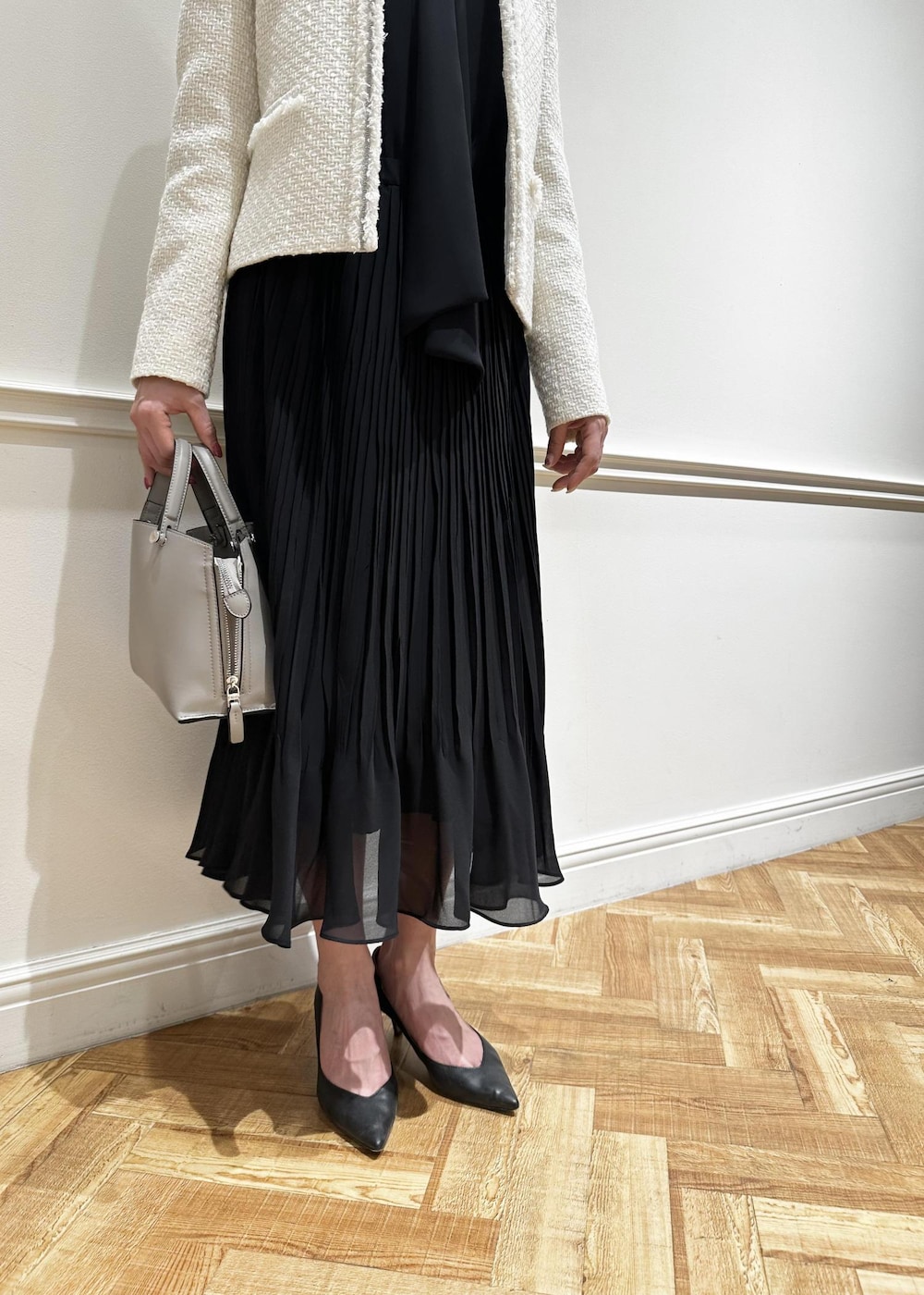 ブラック系のパンプス、ブルー系のワンピース、ホワイト系のノーカラージャケットを着用したレディースの冬コーディネートの5枚目の写真