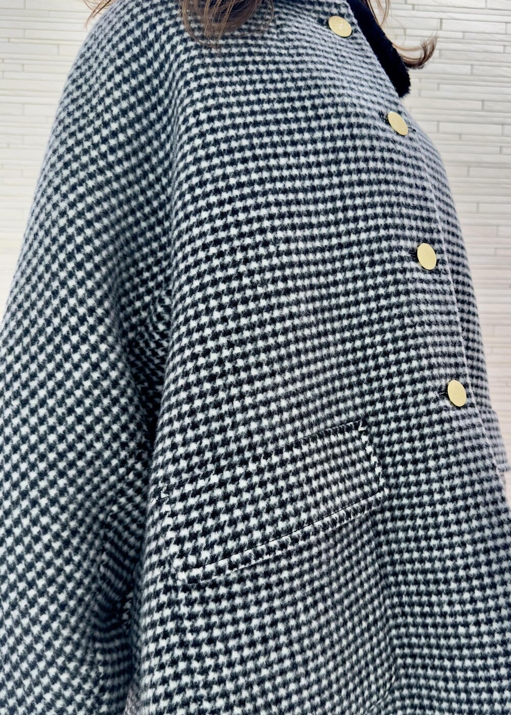 ブラック系のブーツ、ブラック系のその他アウター、イエロー系のハンドバッグを着用したレディースの冬コーディネートの4枚目の写真