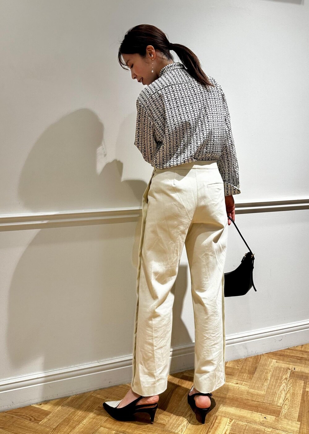 ブラック系のハンドバッグ、ホワイト系のシャツ/ブラウス、ホワイト系のその他パンツを着用したレディースの冬コーディネートの2枚目の写真