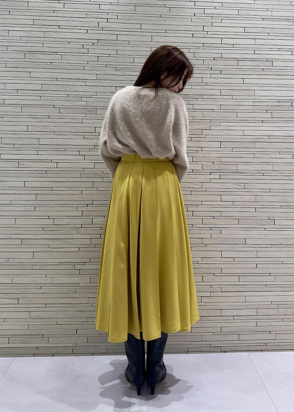 ブラック系のブーツ、ブラック系のその他アウター、イエロー系のハンドバッグを着用したレディースの冬コーディネートの8枚目の写真