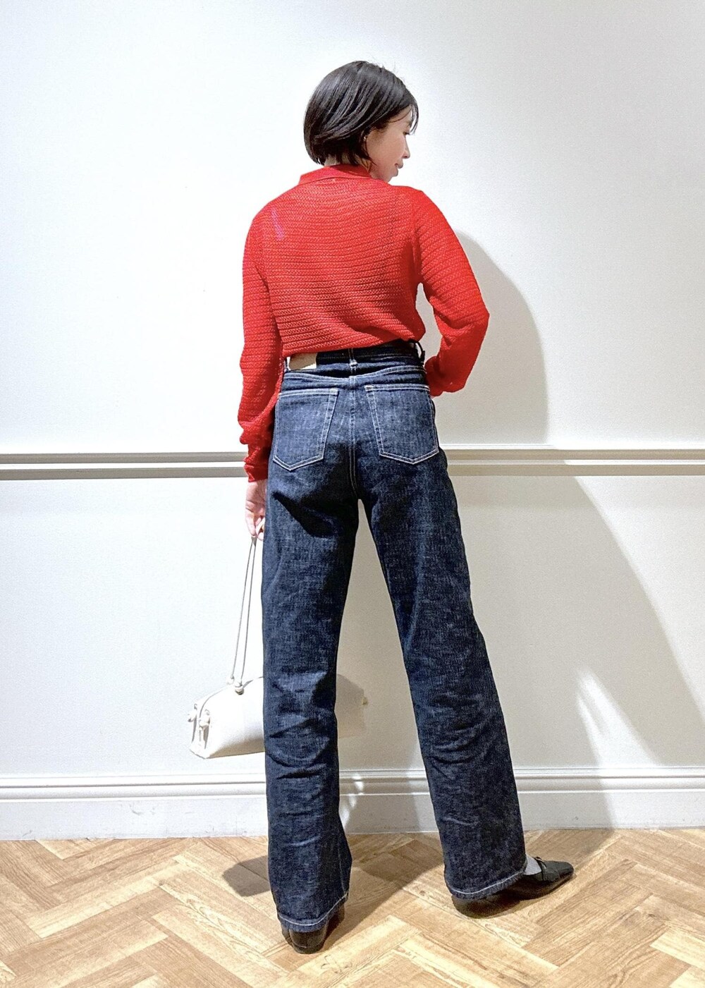 ブラック系のパンプス、ホワイト系のハンドバッグ、レッド系のカーディガン/ボレロを着用したレディースの冬コーディネートの3枚目の写真