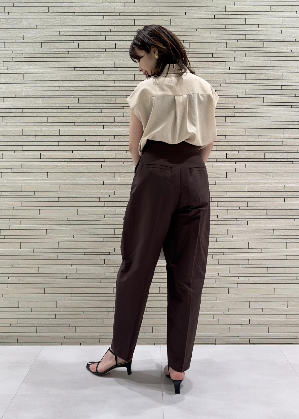 ブラック系のサンダル、ホワイト系のハンドバッグ、レッド系のその他パンツを着用したレディースの夏コーディネートの2枚目の写真