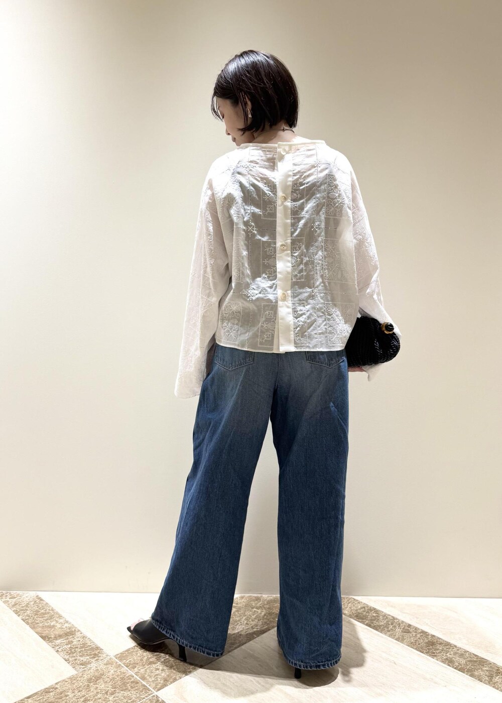 ブルー系のデニムパンツ、ブラック系のサンダル、ホワイト系のシャツ/ブラウスを着用したレディースの春コーディネートの3枚目の写真