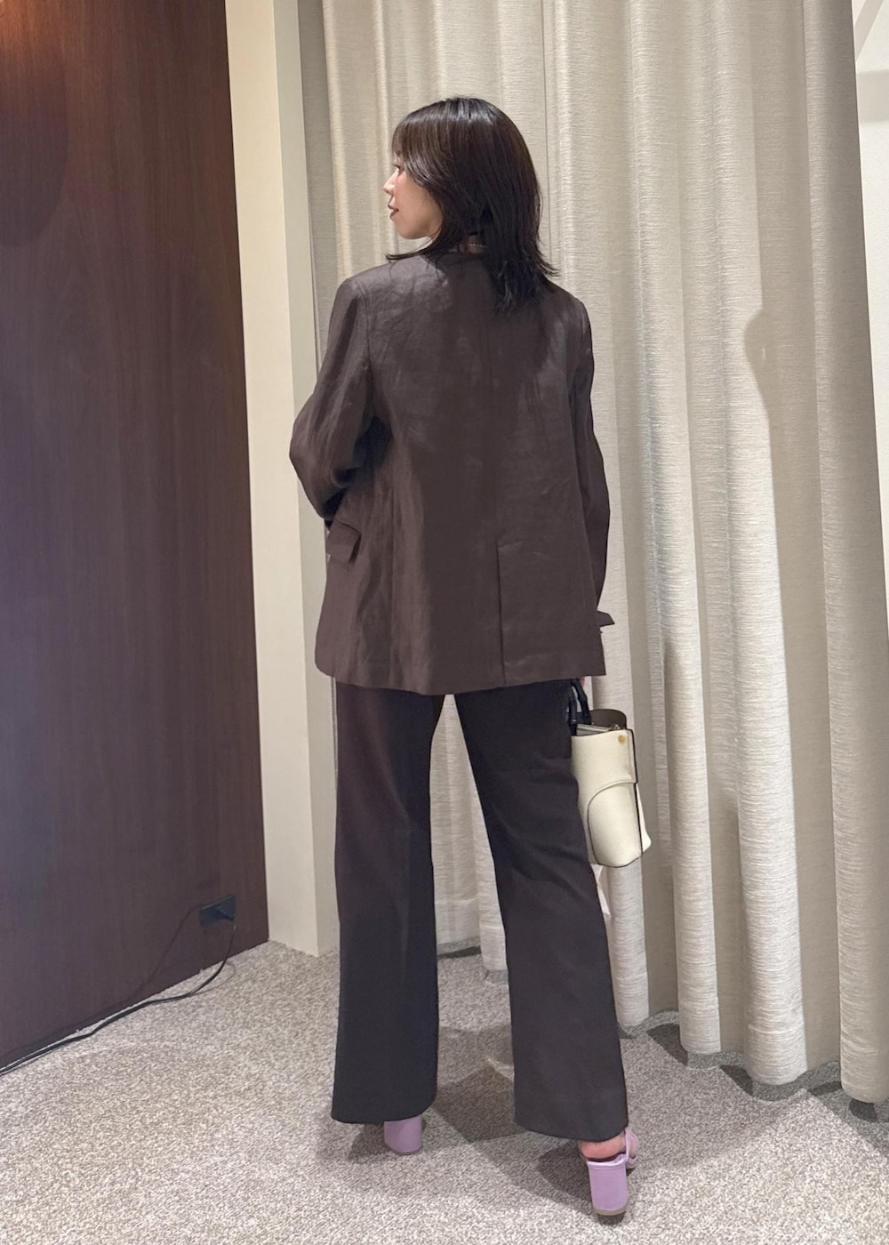 ホワイト系のハンドバッグ、ブラウン系のノーカラージャケット、ブラウン系のTシャツ/カットソーを着用したレディースの春コーディネートの3枚目の写真