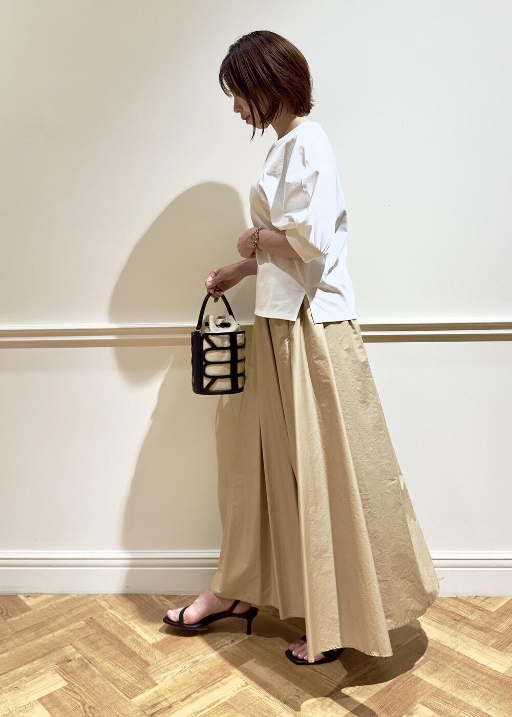 ブラック系のサンダル、ベージュ系のスカート、ホワイト系のTシャツ/カットソーを着用したレディースの夏コーディネートの3枚目の写真