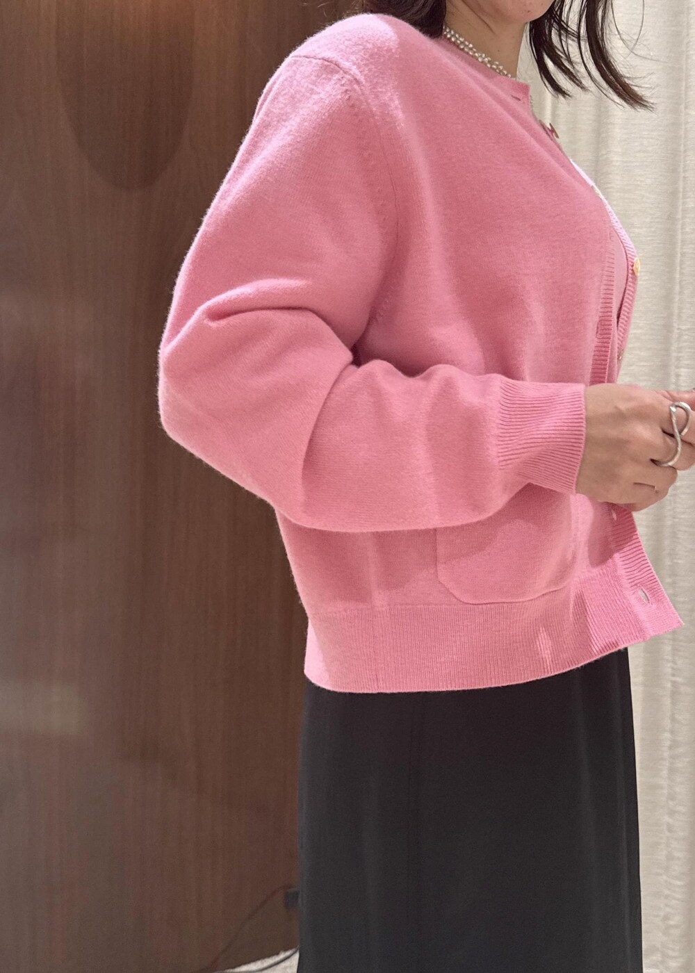 ブラック系のスカート、ベージュ系のハンドバッグ、ブラック系のブーツを着用したレディースの秋コーディネートの8枚目の写真