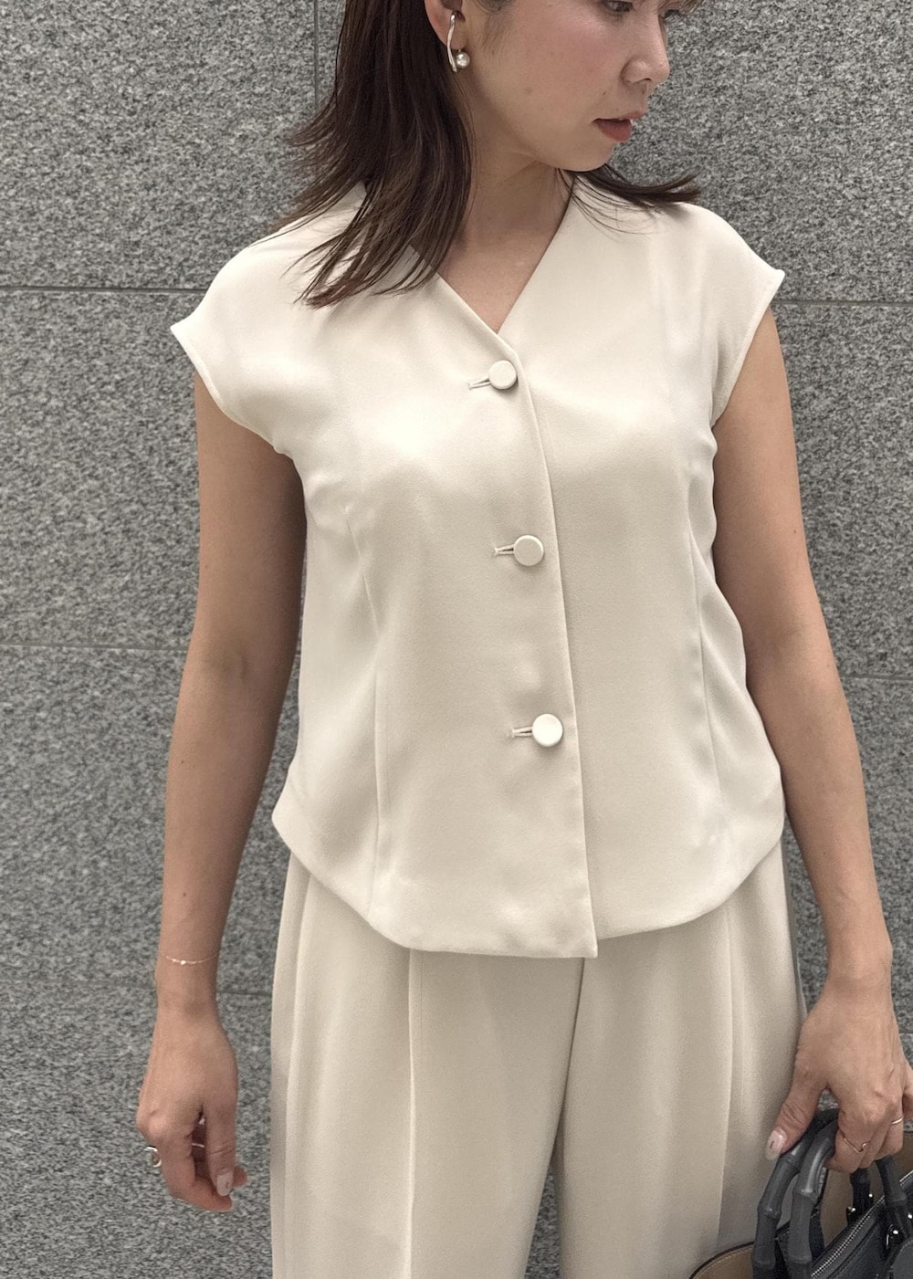 ベージュ系のシャツ/ブラウス、グレー系のハンドバッグ、ベージュ系のその他パンツを着用したレディースの春コーディネートの4枚目の写真