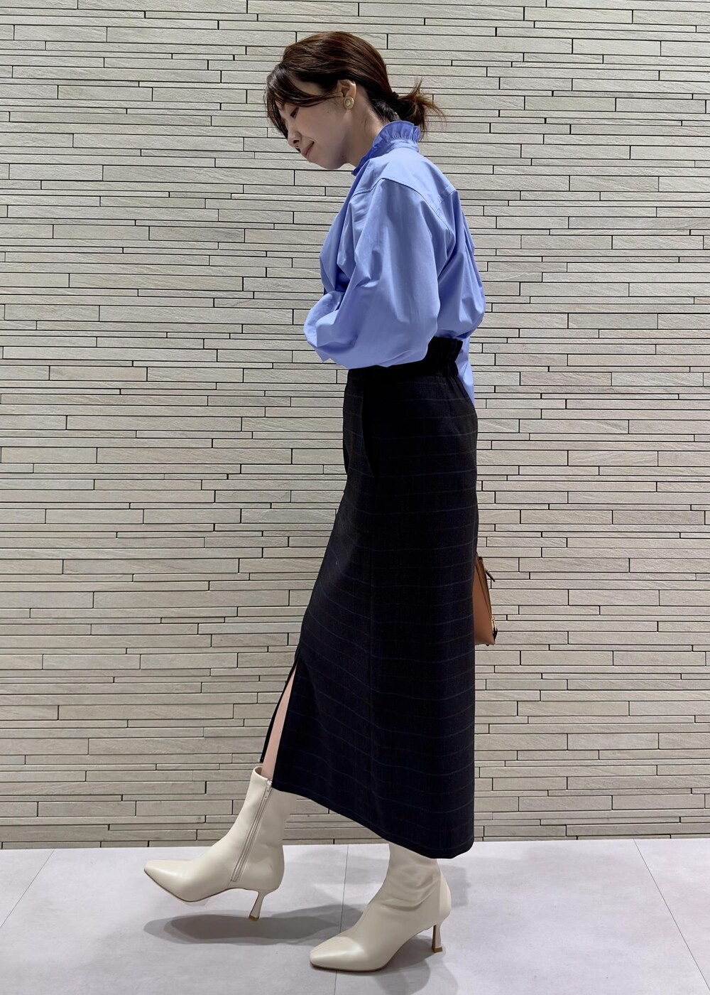 ブルー系のスカート、ホワイト系のブーツ、ブルー系のシャツ/ブラウスを着用したレディースの秋コーディネートの3枚目の写真