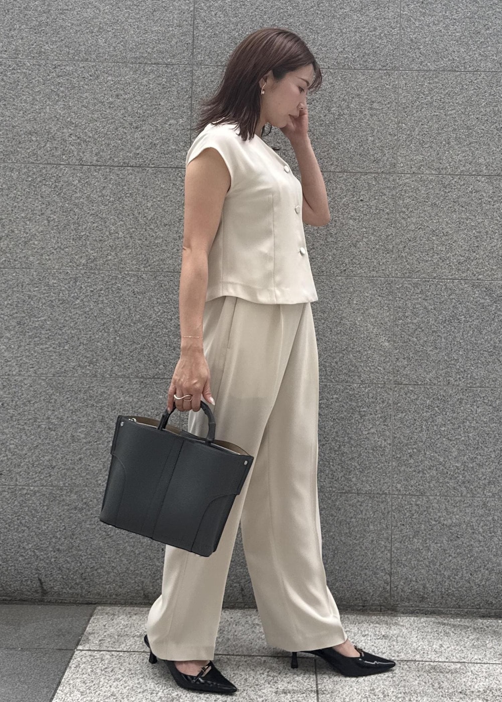 ベージュ系のシャツ/ブラウス、グレー系のハンドバッグ、ベージュ系のその他パンツを着用したレディースの春コーディネートの2枚目の写真