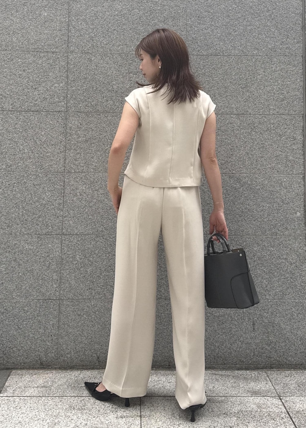 ベージュ系のシャツ/ブラウス、グレー系のハンドバッグ、ベージュ系のその他パンツを着用したレディースの春コーディネートの3枚目の写真