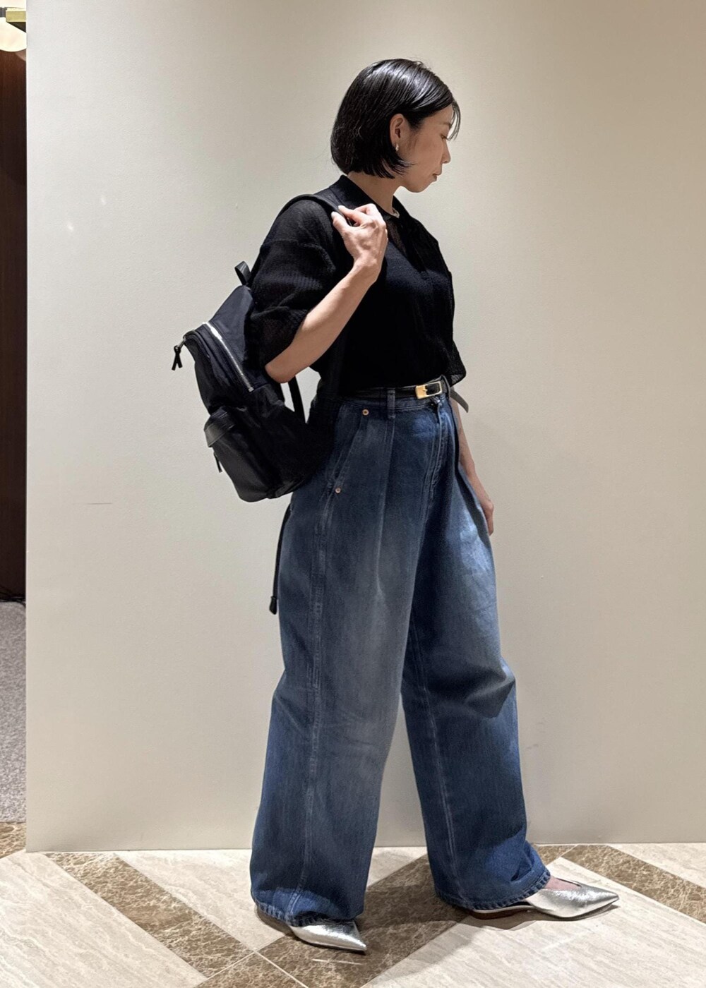 ブルー系のデニムパンツ、シルバー系のパンプス、ブラック系のカーディガン/ボレロを着用したレディースの夏コーディネートの2枚目の写真