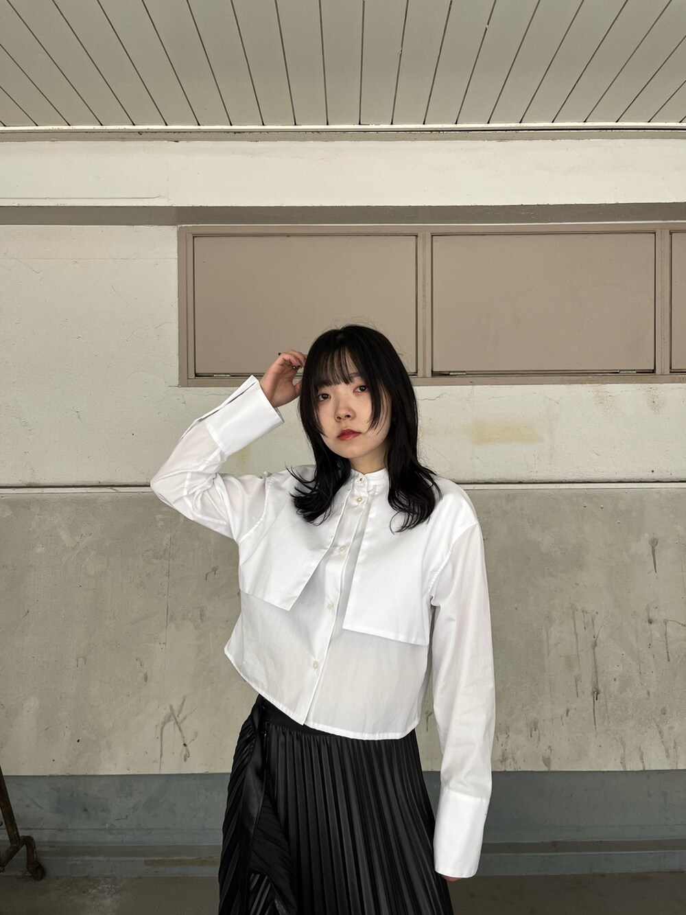 ホワイト系のシャツ/ブラウス、ブラック系のスカート、ブラック系のブーツを着用したレディースの秋コーディネートの5枚目の写真