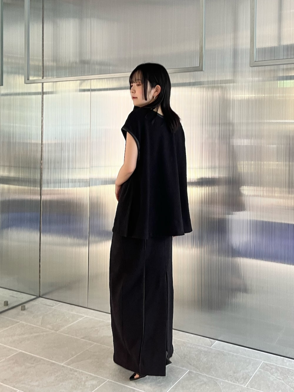 ブラック系のTシャツ/カットソー、ブラック系のスカートを着用したレディースの春コーディネートの3枚目の写真