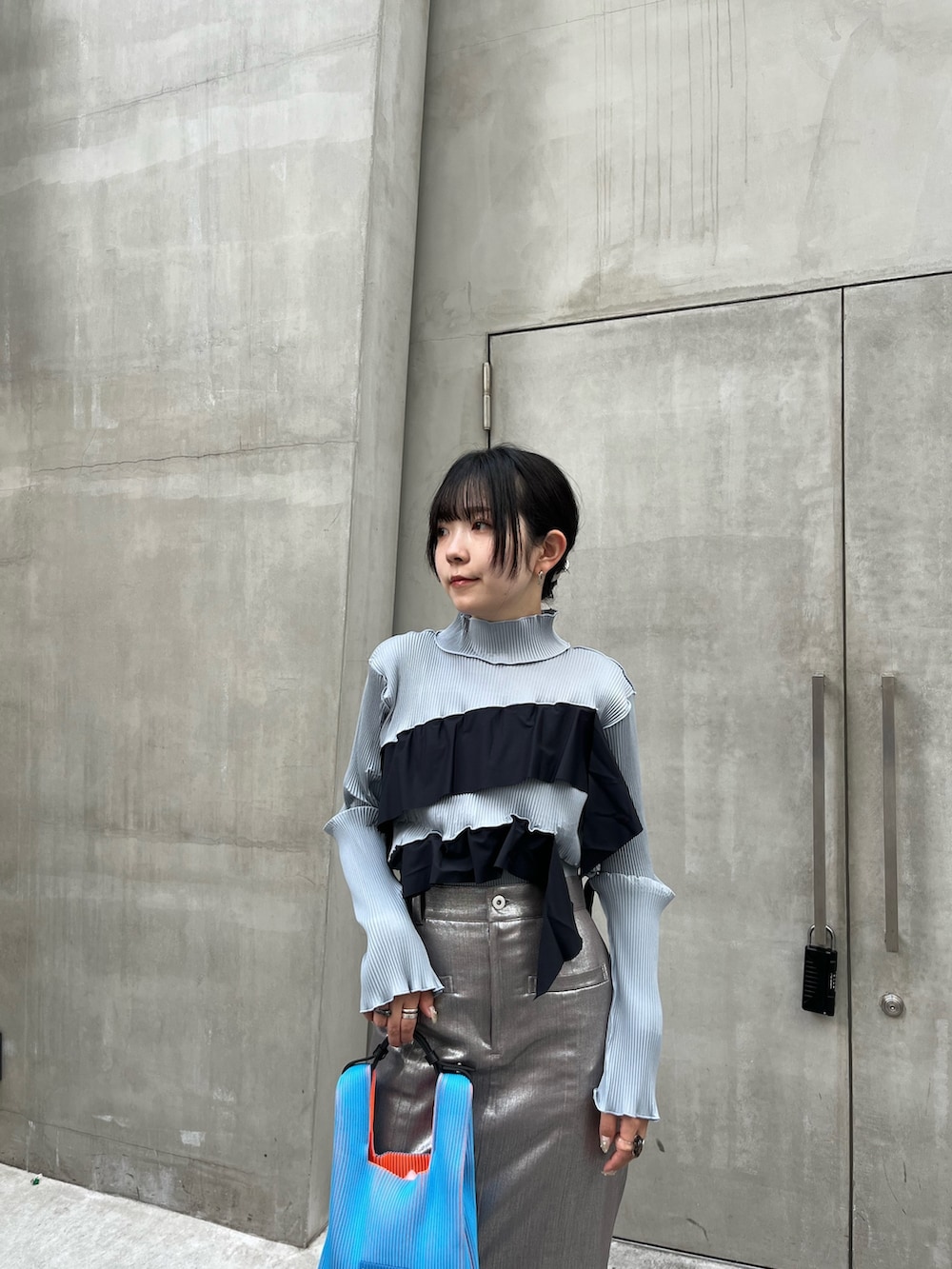 グレー系のTシャツ/カットソー、シルバー系のスカートを着用したレディースの秋コーディネートの4枚目の写真