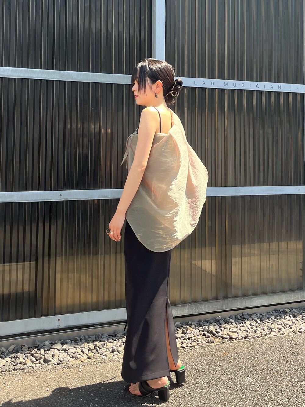 ブラック系のスカート、グリーン系のシャツ/ブラウスを着用したレディースの夏コーディネートの5枚目の写真