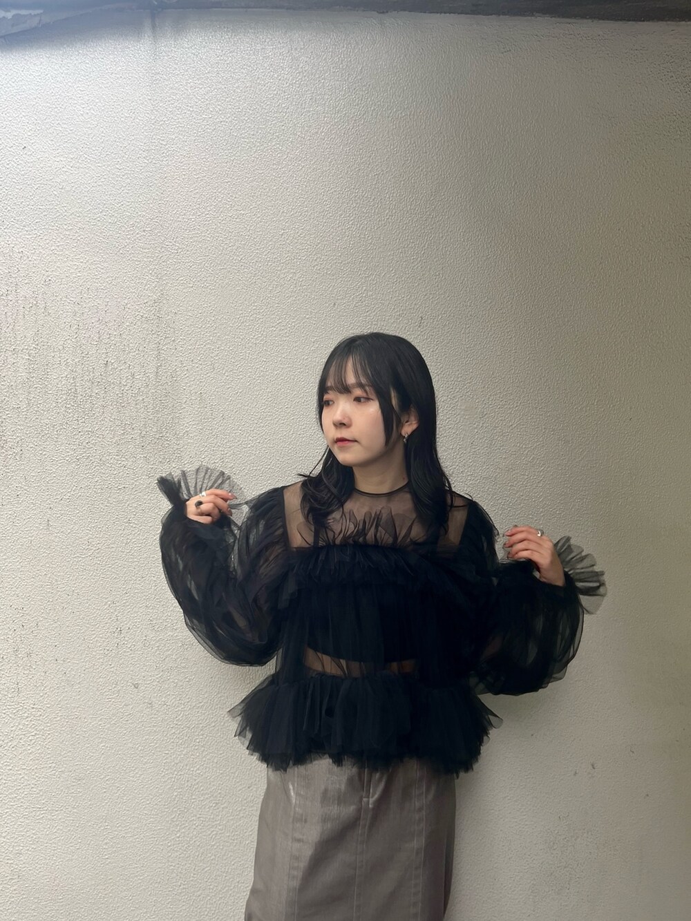 ブラック系のシャツ/ブラウス、シルバー系のスカート、ブラック系のブーツを着用したレディースの秋コーディネートの5枚目の写真