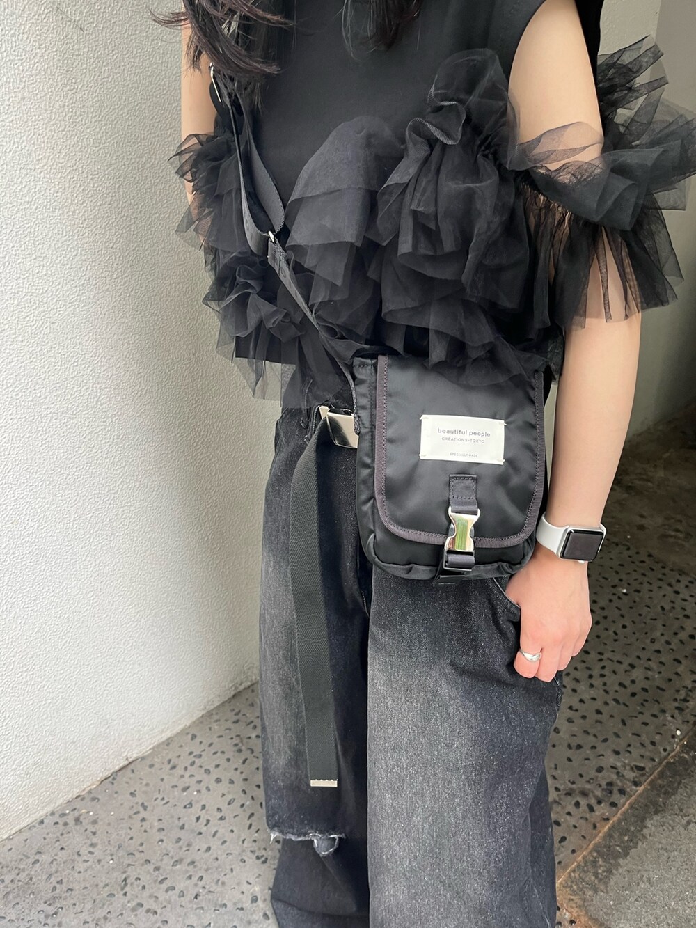 ブラック系のデニムパンツ、ブラック系のTシャツ/カットソー、ブラック系のショルダーバッグを着用したレディースの夏コーディネートの4枚目の写真