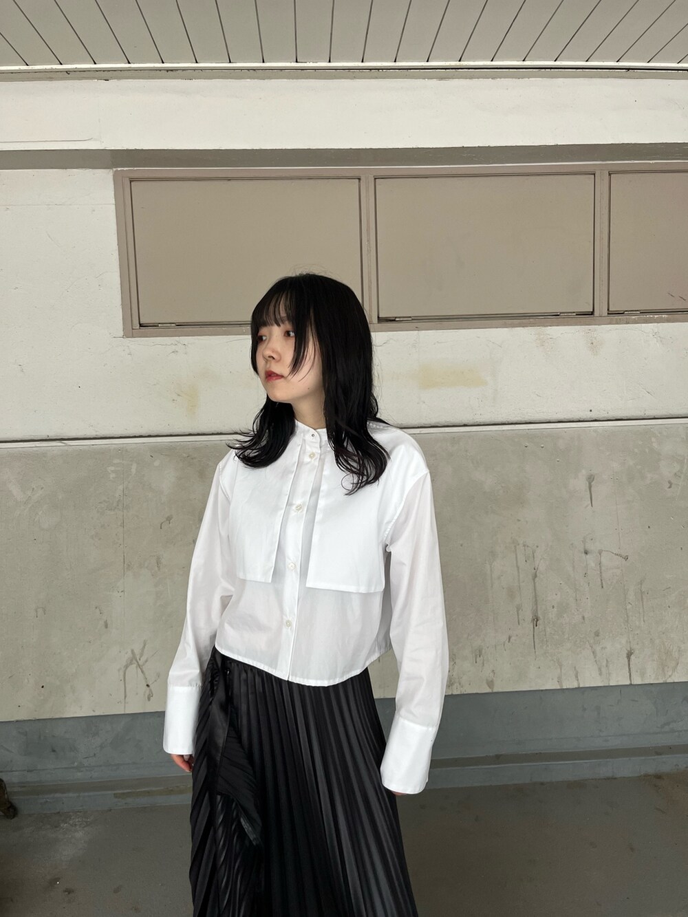 ホワイト系のシャツ/ブラウス、ブラック系のスカート、ブラック系のブーツを着用したレディースの秋コーディネートの4枚目の写真