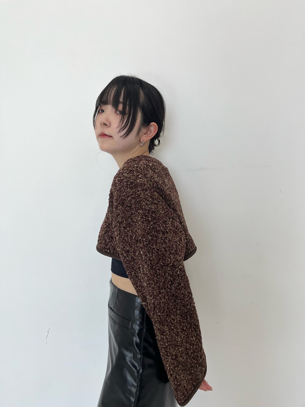 ブラック系のスカート、ブラック系のブーツを着用したレディースの秋コーディネートの5枚目の写真