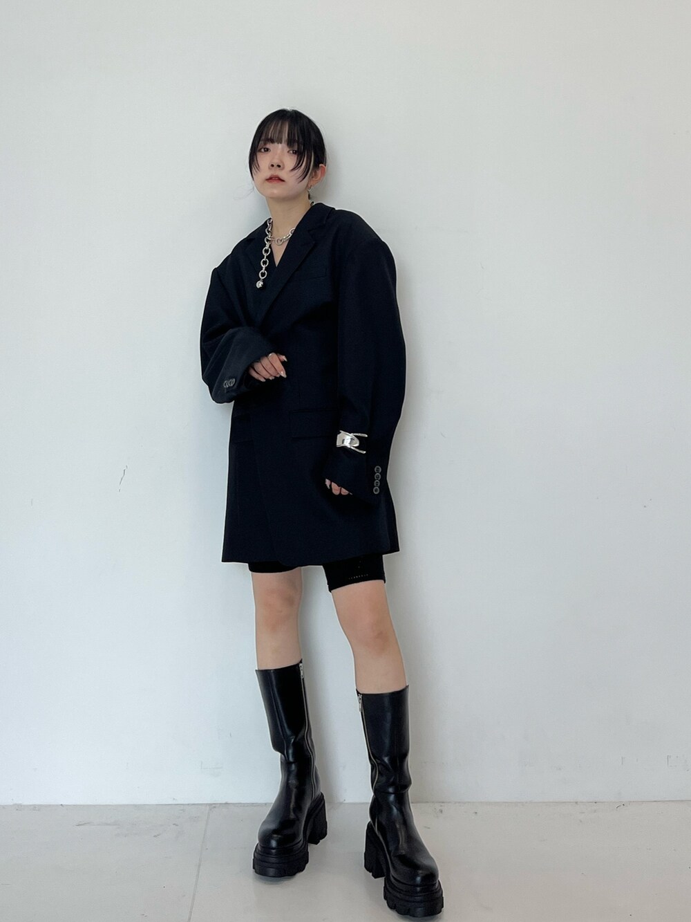 ブラック系のテーラードジャケット、ブラック系のブーツを着用したレディースの秋コーディネートの3枚目の写真