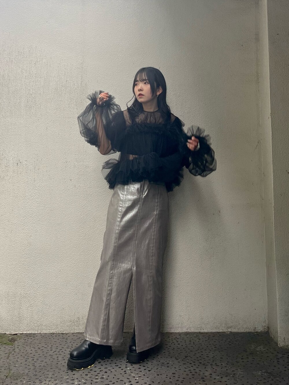 ブラック系のシャツ/ブラウス、シルバー系のスカート、ブラック系のブーツを着用したレディースの秋コーディネートの2枚目の写真