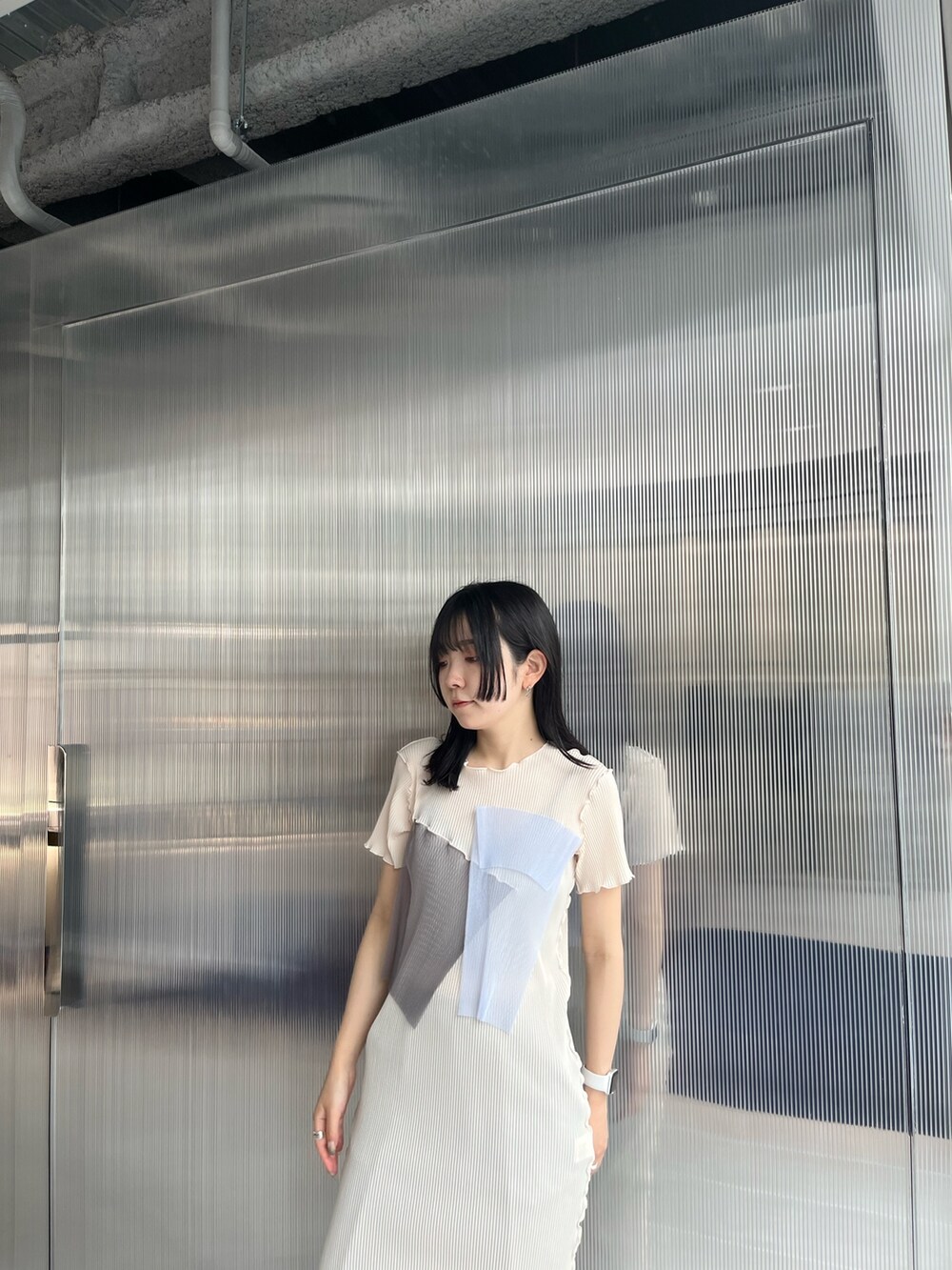 ベージュ系のワンピース、ブラック系のスラックスを着用したレディースの夏コーディネートの4枚目の写真