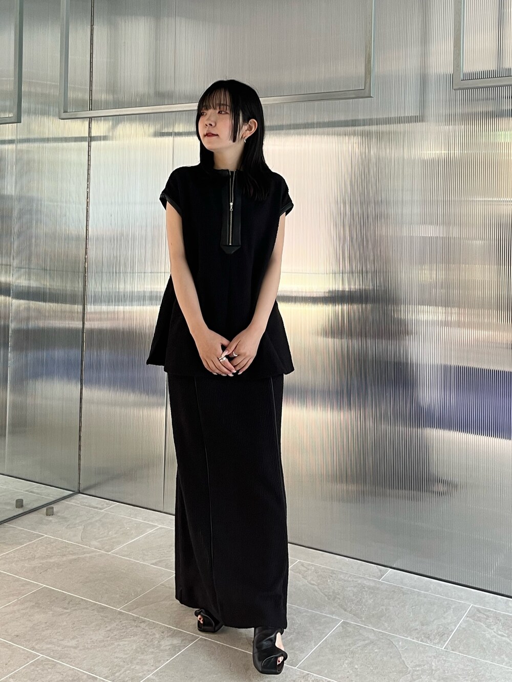 ブラック系のTシャツ/カットソー、ブラック系のスカートを着用したレディースの春コーディネートの2枚目の写真