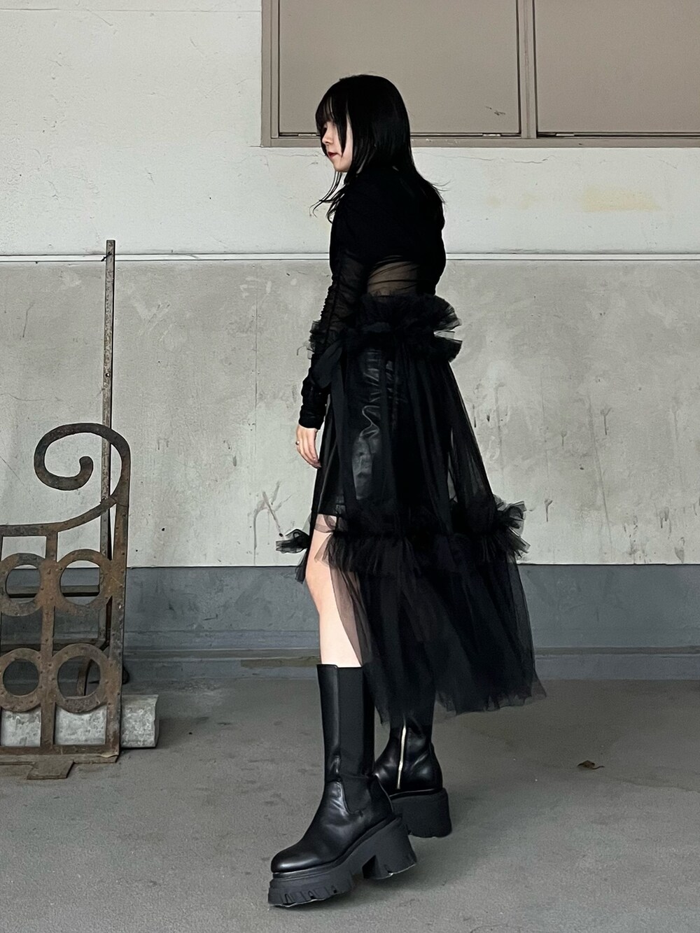 ブラック系のスカート、ブラック系のスカート、ブラック系のブーツを着用したレディースの秋コーディネートの2枚目の写真