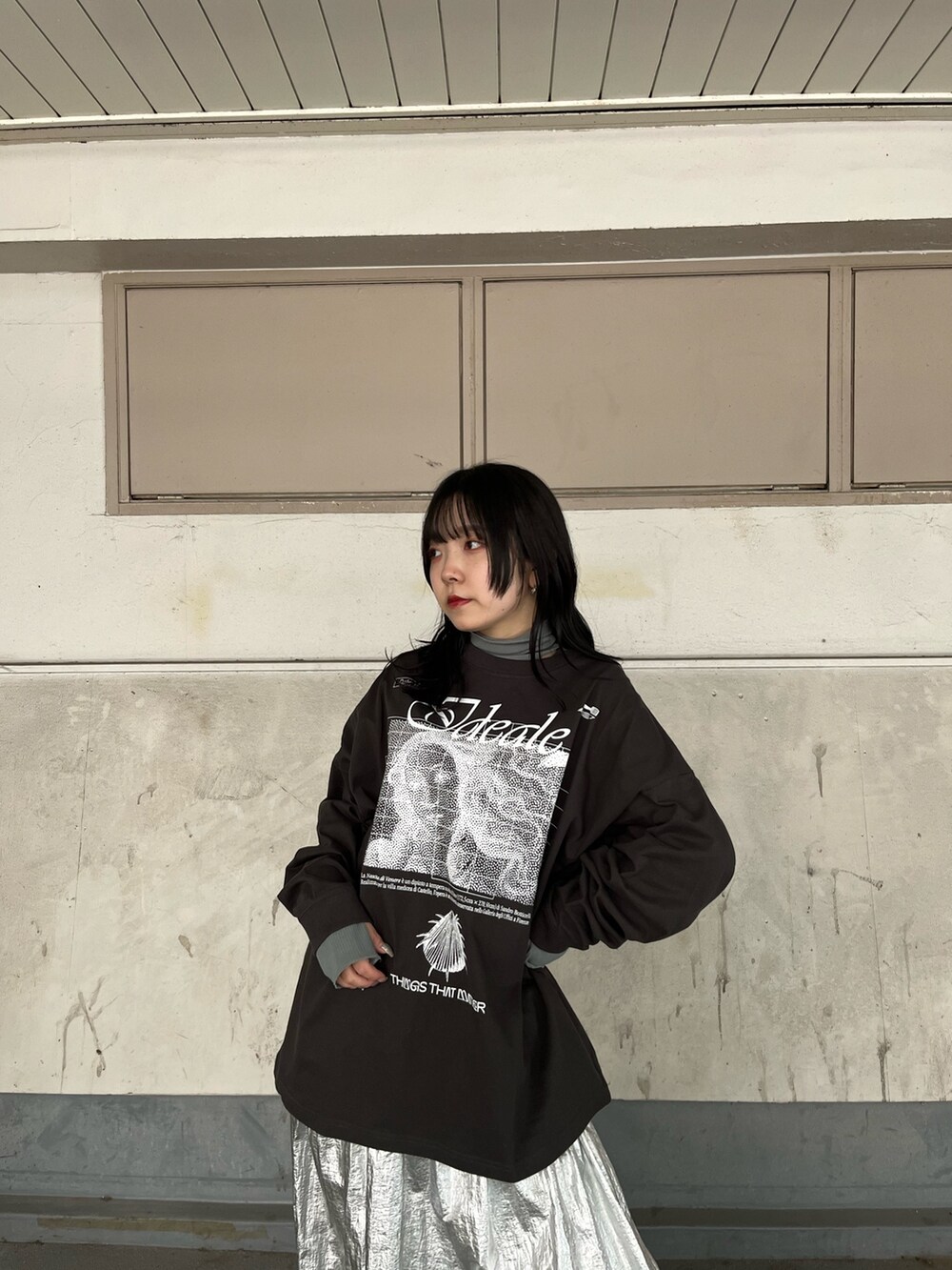 シルバー系のスカート、ブラック系のブーツを着用したレディースの秋コーディネートの4枚目の写真