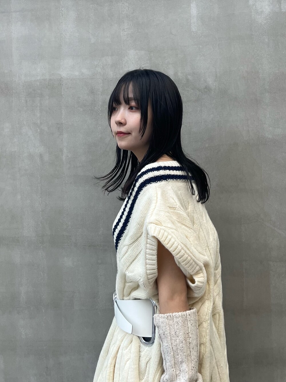 ブラック系のスカート、ブラック系のブーツ、ベージュ系のアームカバーを着用したレディースの秋コーディネートの4枚目の写真