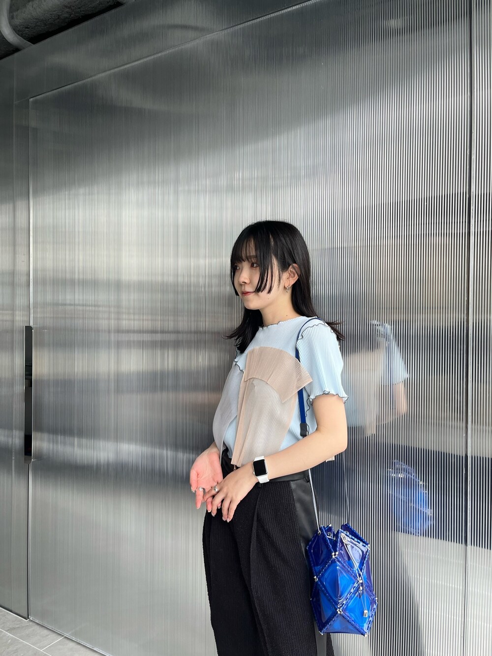 ブラック系のスラックス、ブルー系のTシャツ/カットソーを着用したレディースの夏コーディネートの3枚目の写真