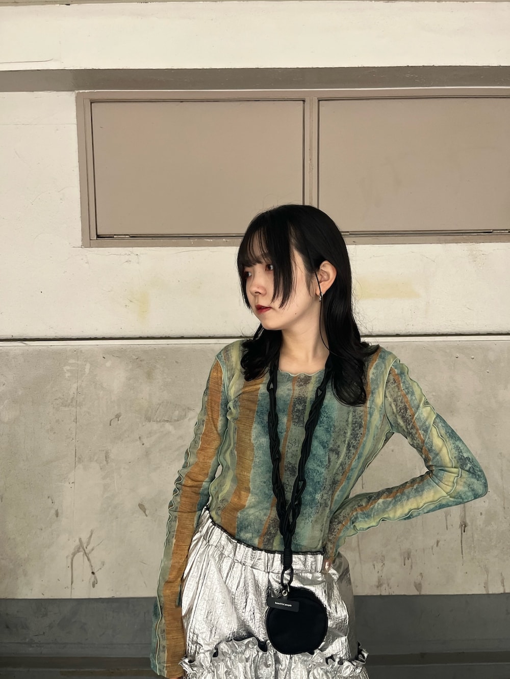シルバー系のスカート、その他のTシャツ/カットソー、ブラック系のブーツを着用したレディースの秋コーディネートの4枚目の写真