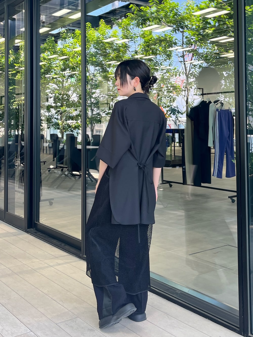 ブラック系のシャツ/ブラウス、ブラック系のスラックスを着用したレディースの夏コーディネートの2枚目の写真