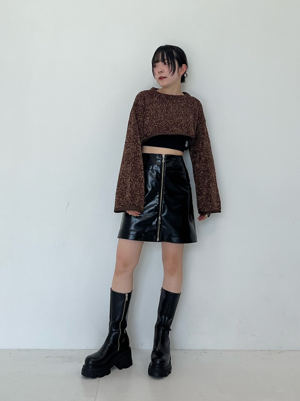 ブラック系のスカート、ブラック系のブーツを着用したレディースの秋コーディネートの3枚目の写真