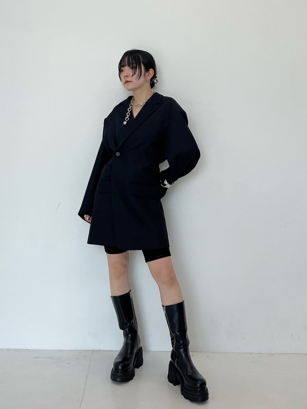 ブラック系のテーラードジャケット、ブラック系のブーツを着用したレディースの秋コーディネートの2枚目の写真