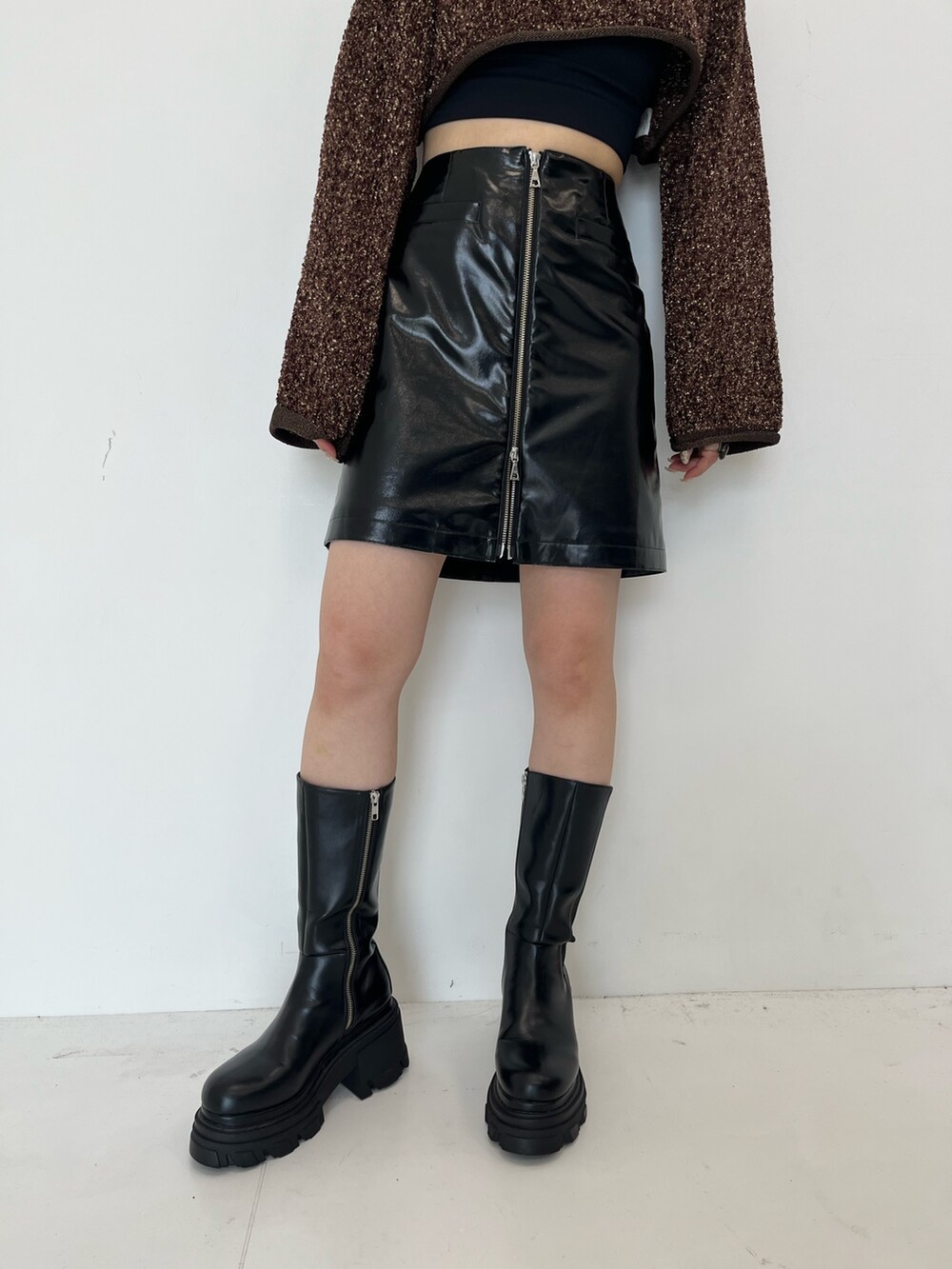 ブラック系のスカート、ブラック系のブーツを着用したレディースの秋コーディネートの4枚目の写真