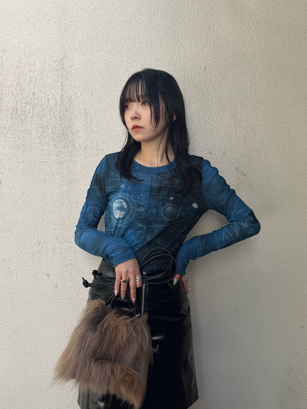 ブラック系のスカート、ブルー系のTシャツ/カットソー、ブラック系のブーツを着用したレディースの秋コーディネートの4枚目の写真