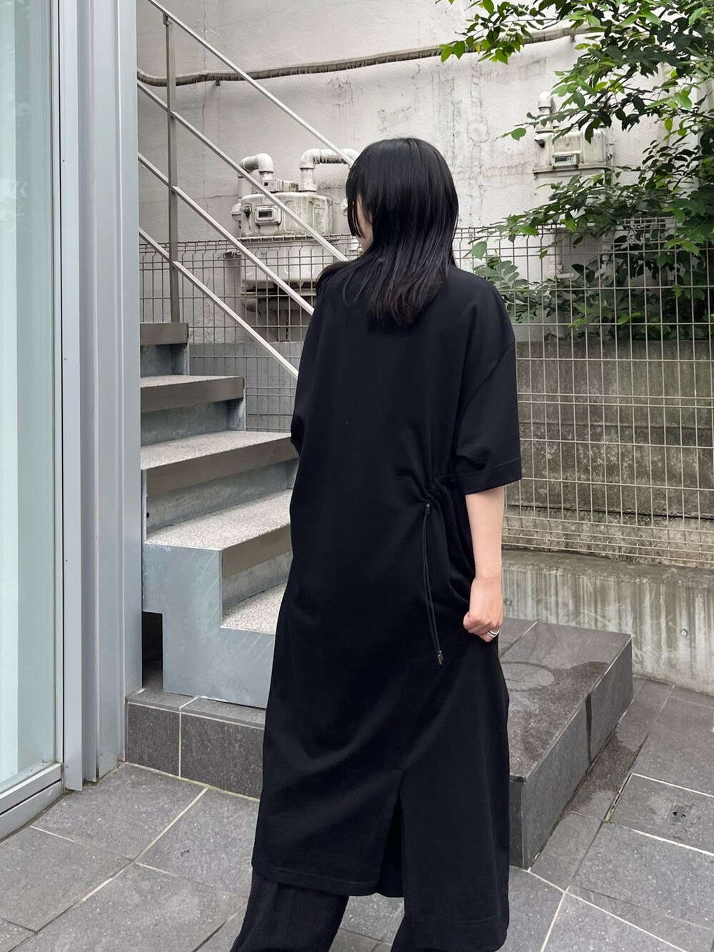 ブラック系のスラックスを着用したレディースの夏コーディネートの4枚目の写真