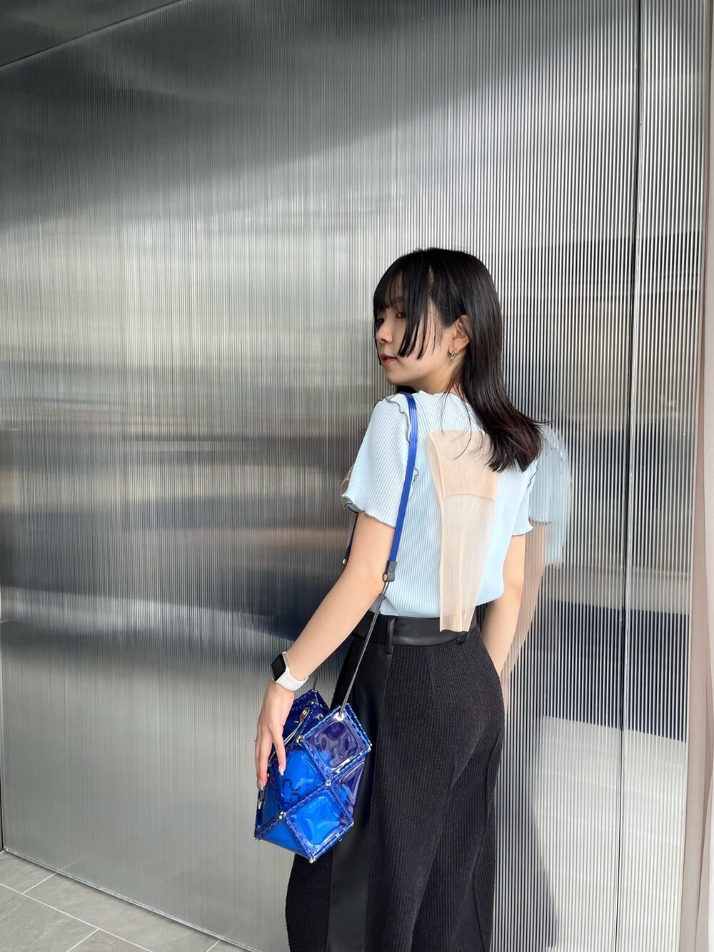 ブラック系のスラックス、ブルー系のTシャツ/カットソーを着用したレディースの夏コーディネートの4枚目の写真