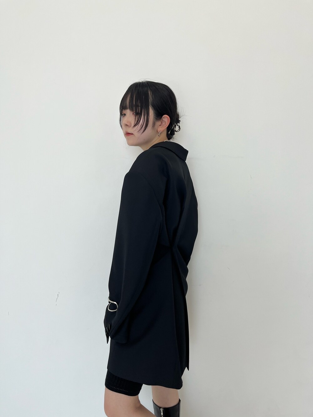 ブラック系のテーラードジャケット、ブラック系のブーツを着用したレディースの秋コーディネートの5枚目の写真