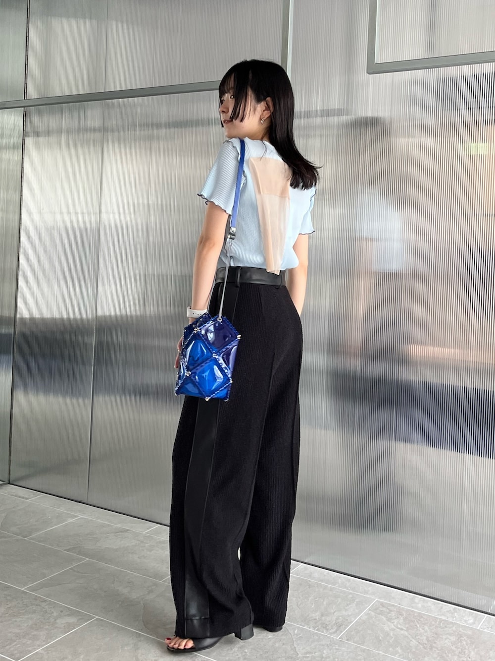 ブラック系のスラックス、ブルー系のTシャツ/カットソーを着用したレディースの夏コーディネートの2枚目の写真