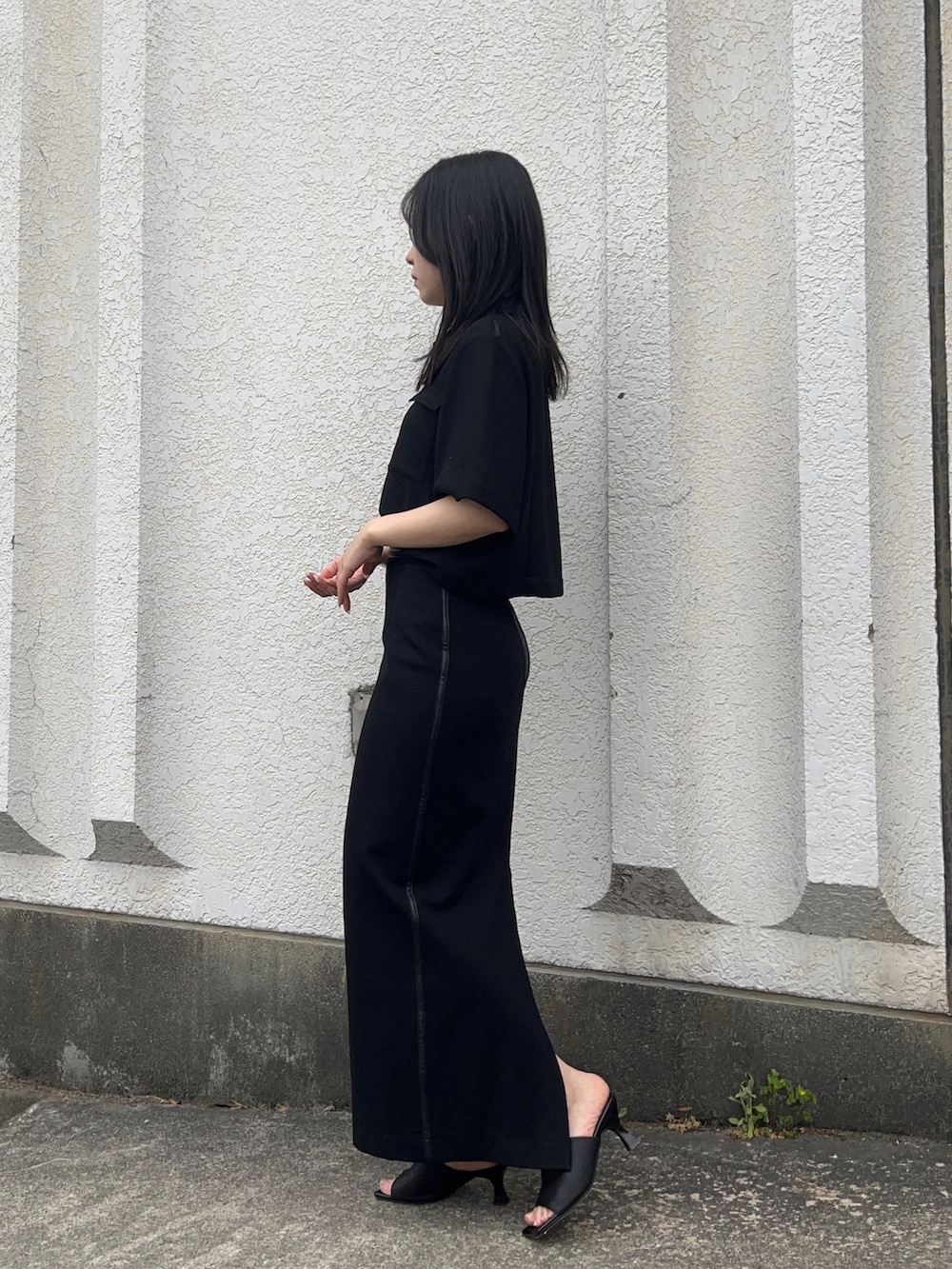 ブラック系のスカート、ブラック系のシャツ/ブラウス、ブラック系のサンダルを着用したレディースの春コーディネートの2枚目の写真