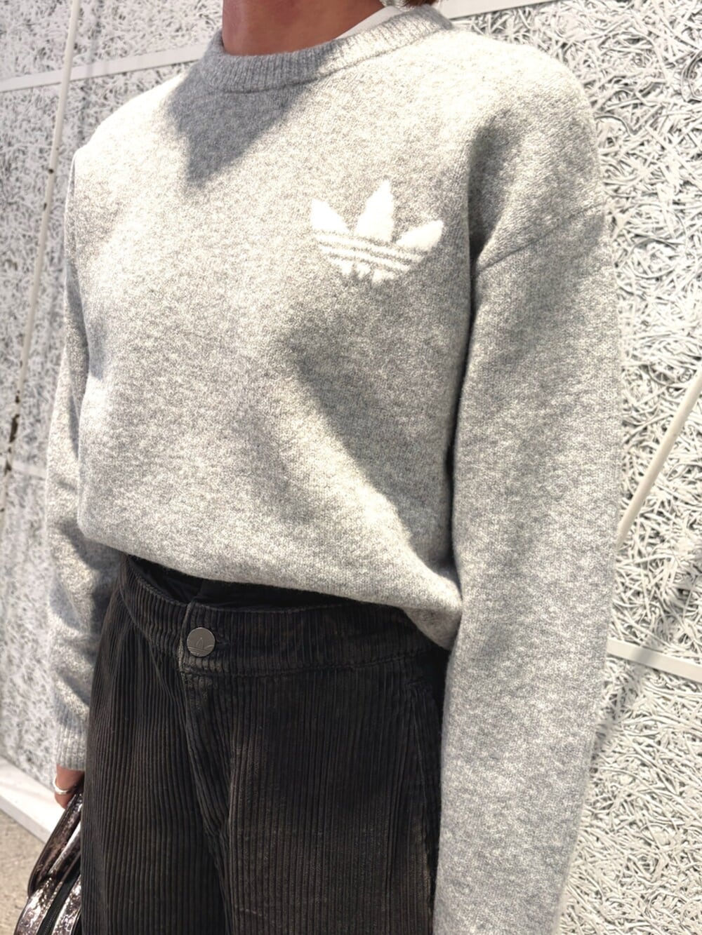 グレー系のニット/セーター、ブラック系のスウェットパンツ、グレー系のショルダーバッグを着用したレディースの冬コーディネートの2枚目の写真