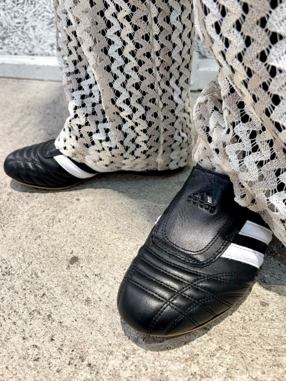 ブラウン系のナイロンジャケット、ブラック系のショルダーバッグ、ホワイト系のスウェットパンツを着用したレディースの春コーディネートの6枚目の写真