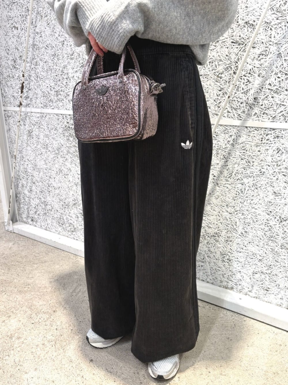 グレー系のニット/セーター、ブラック系のスウェットパンツ、グレー系のショルダーバッグを着用したレディースの冬コーディネートの3枚目の写真