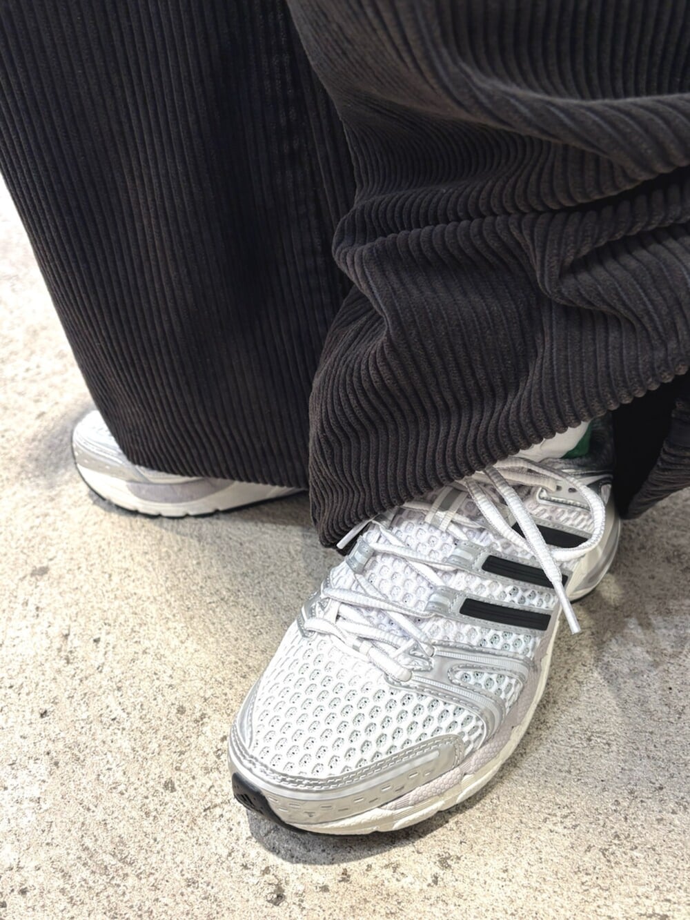 グレー系のニット/セーター、ブラック系のスウェットパンツ、グレー系のショルダーバッグを着用したレディースの冬コーディネートの4枚目の写真