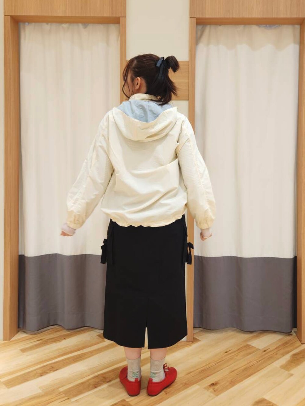 レッド系のドレスシューズ、ブラック系のスカート、ホワイト系のブルゾンを着用したレディースの春コーディネートの3枚目の写真
